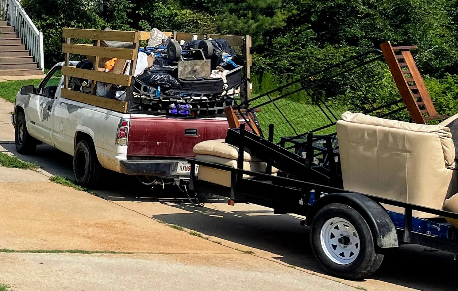 Pickup truck and trailer loaded with household junk for removal